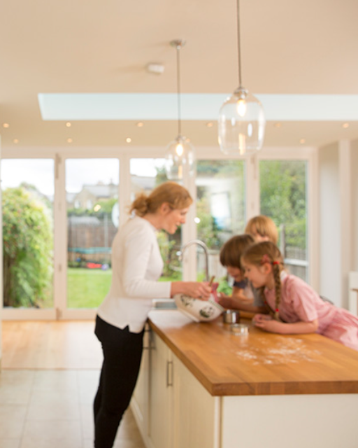 Plumis wall unit beside a kitchen where a family is baking